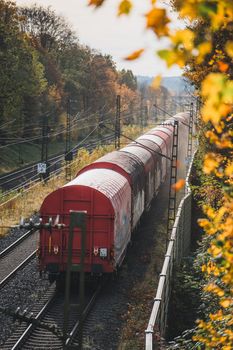 A cargo train travels through a picturesque autumn scene in Bielefeld, Germany.