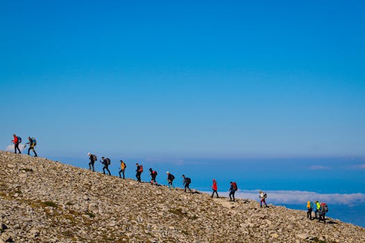 Group of hikers trekking uphill under clear sky on a rocky slope in Bursa, Türkiye.