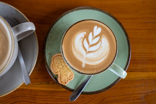 Beautiful latte art on coffee served in Bali, Indonesia with a cute cookie on the side.