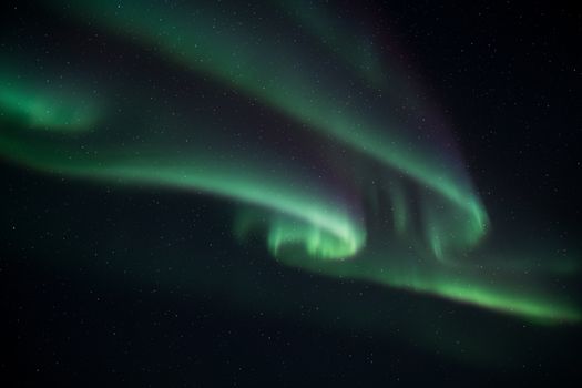 Vibrant Northern Lights dance across the night sky, creating a mesmerizing celestial display.