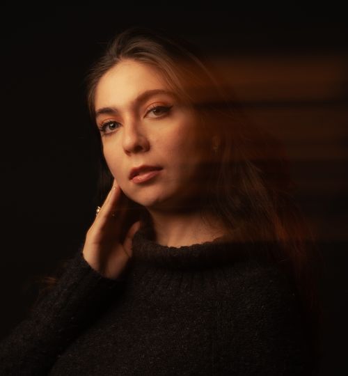 Free Dramatic portrait of a woman with soft motion blur and warm lighting. Stock Photo