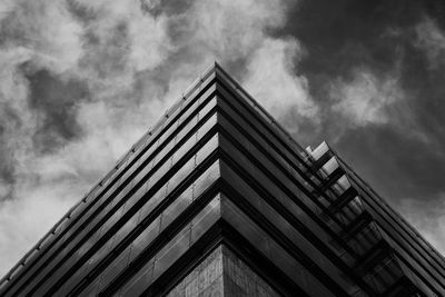 Black and white photo of a modern glass building against dramatic sky — Photo by outsidethccn dsgn on Pexels