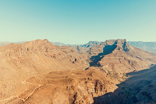 Free Breathtaking aerial view of a desert valley with rugged terrain and clear skies. Stock Photo