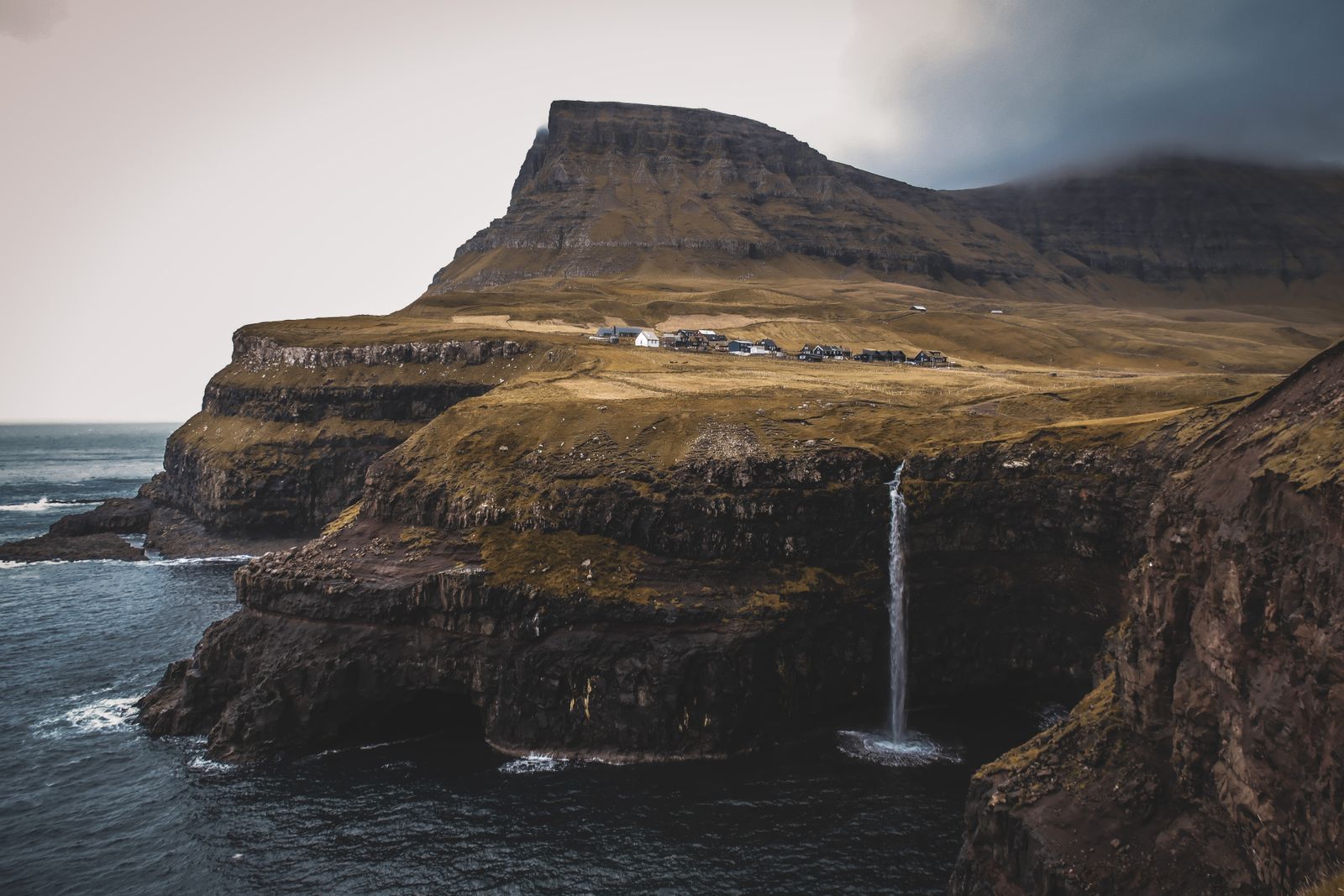 Green sea cliffs and a waterfall dropping into the North Atlantic