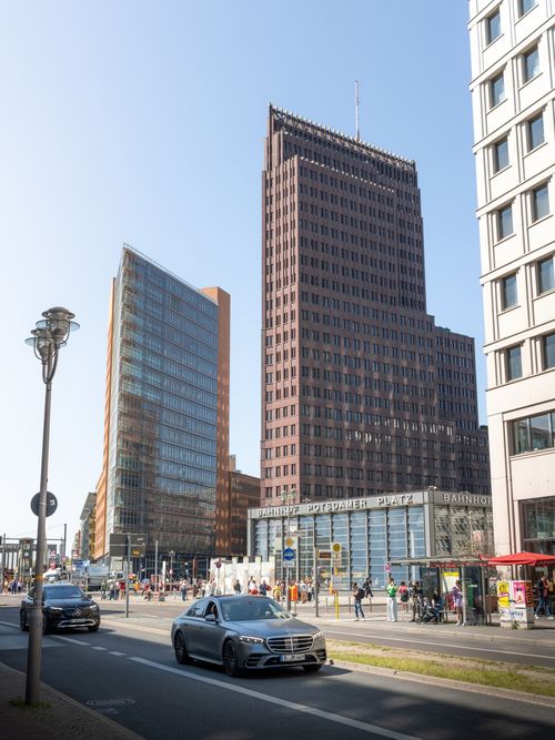 Free View of modern architecture at Potsdamer Platz, Berlin, with cars and pedestrians in daylight. Stock Photo