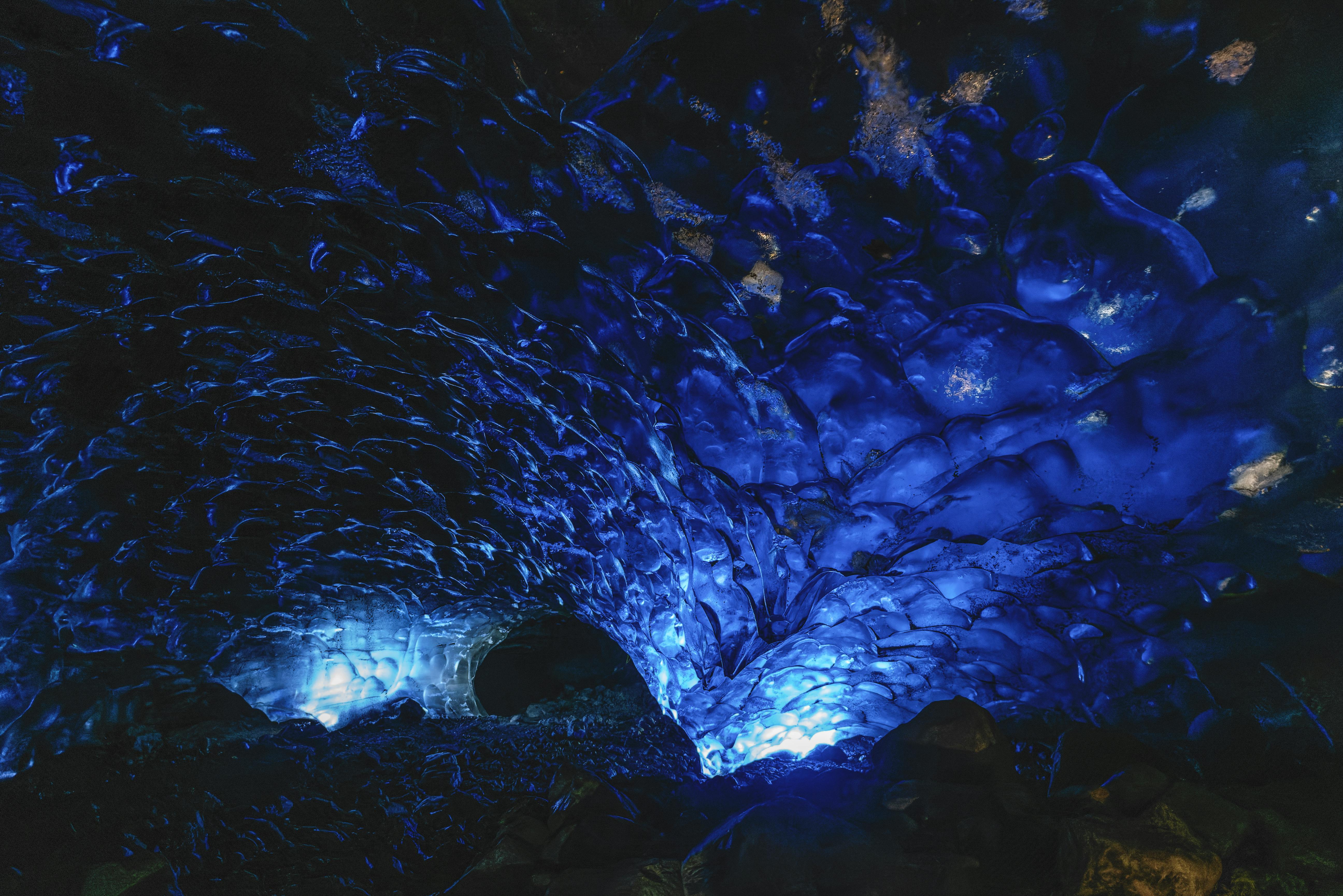 Captivating view inside a naturally lit blue ice cave with textured walls.
