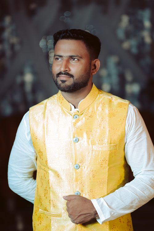 Free Elegantly dressed man in a yellow traditional vest with blurred abstract background. Stock Photo