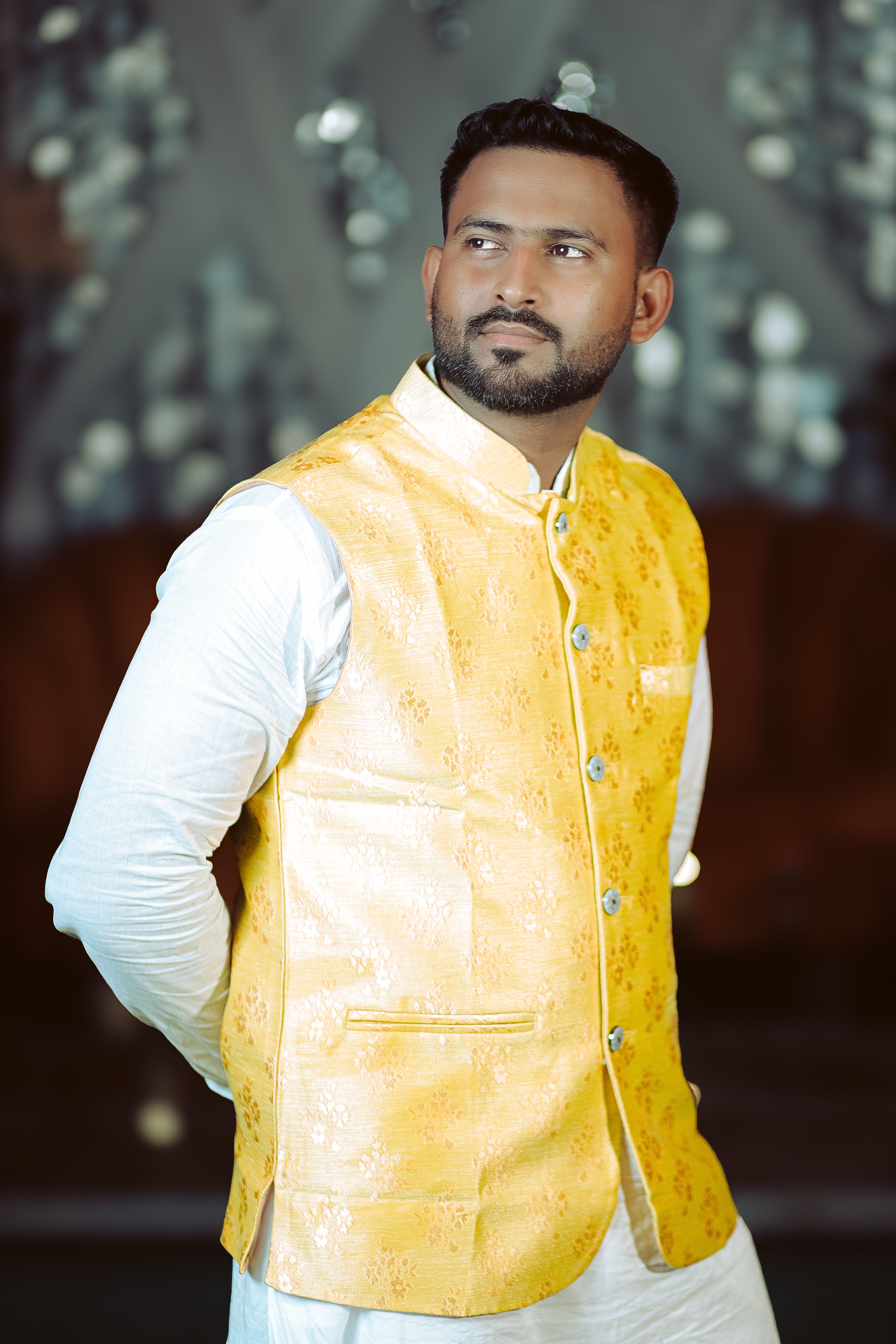 An elegant portrait of a man wearing a traditional yellow vest, exuding confidence and style.
