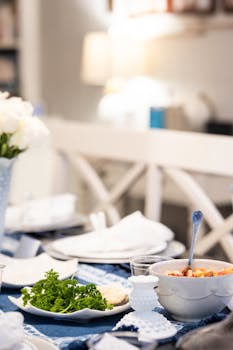 A beautifully set dinner table with white flowers and dishes, creating an elegant indoor ambiance.