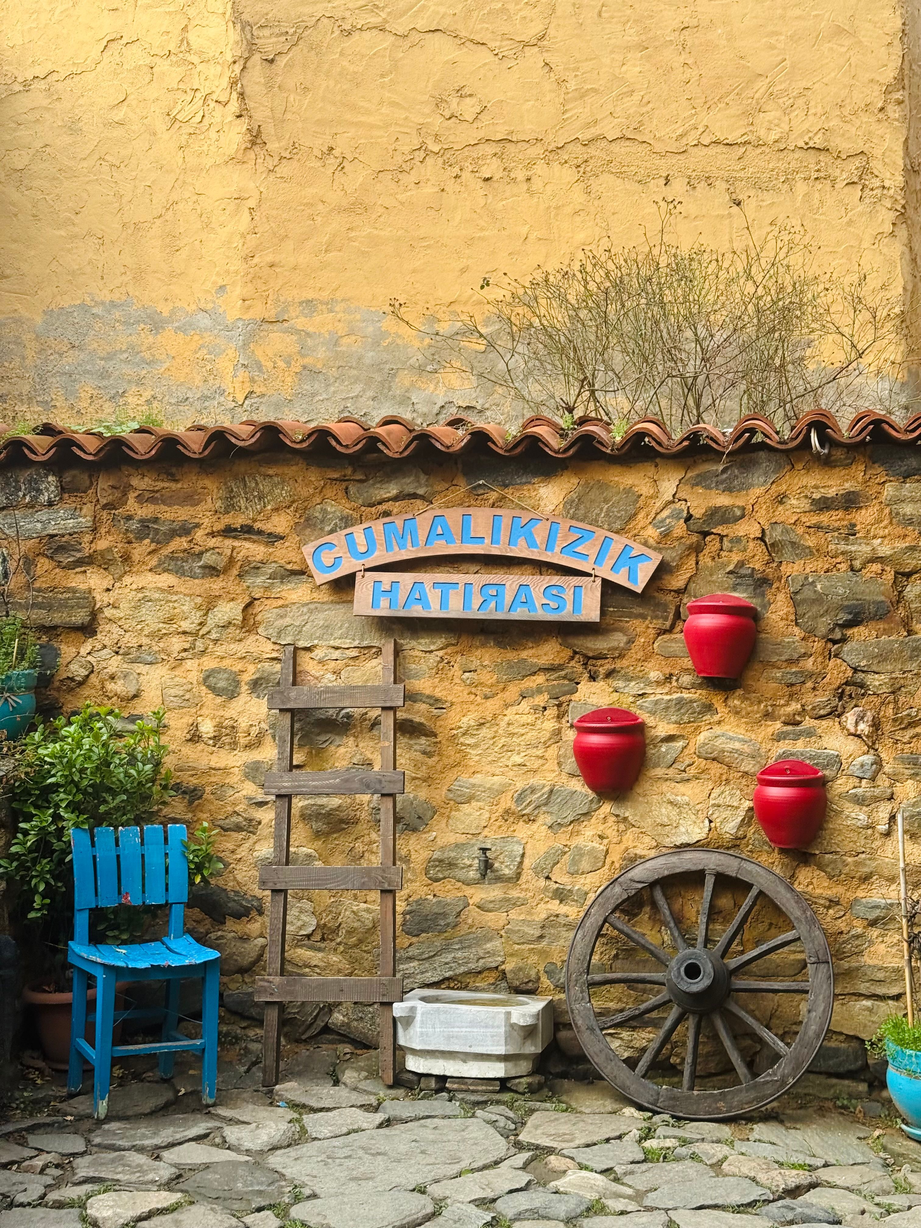 Charming rustic wall with pots and a wheel in Cumalıkızık, Bursa.