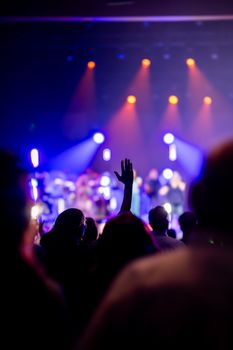 A lively concert scene with enthusiastic audience enjoying vibrant stage lights.