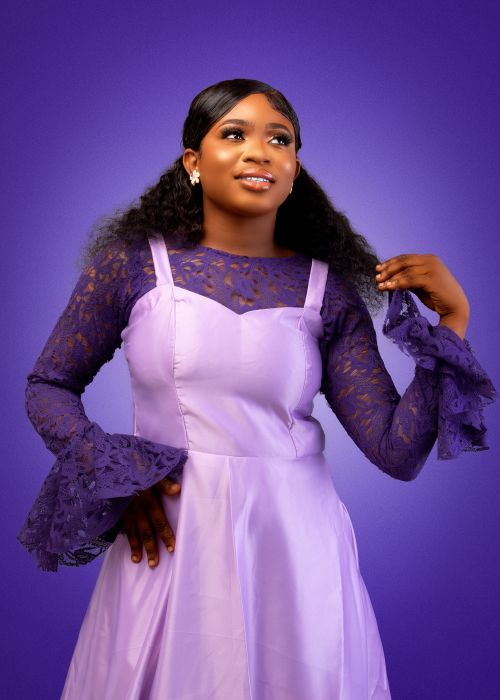 Free Portrait of a woman wearing a stylish purple lace dress against a matching purple background. Stock Photo