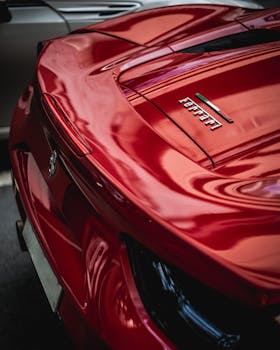 Detailed view of a red Ferrari sports car rear with iconic branding and sleek design.