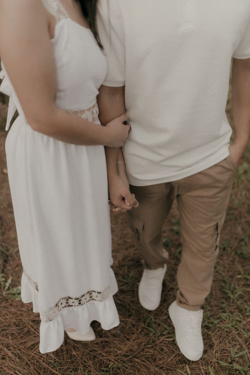 Free Romantic couple holding hands outdoors, wearing casual attire with soft focus. Stock Photo