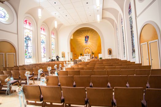 Beautiful church interior featuring stained glass windows and empty wooden pews, ready for worship.