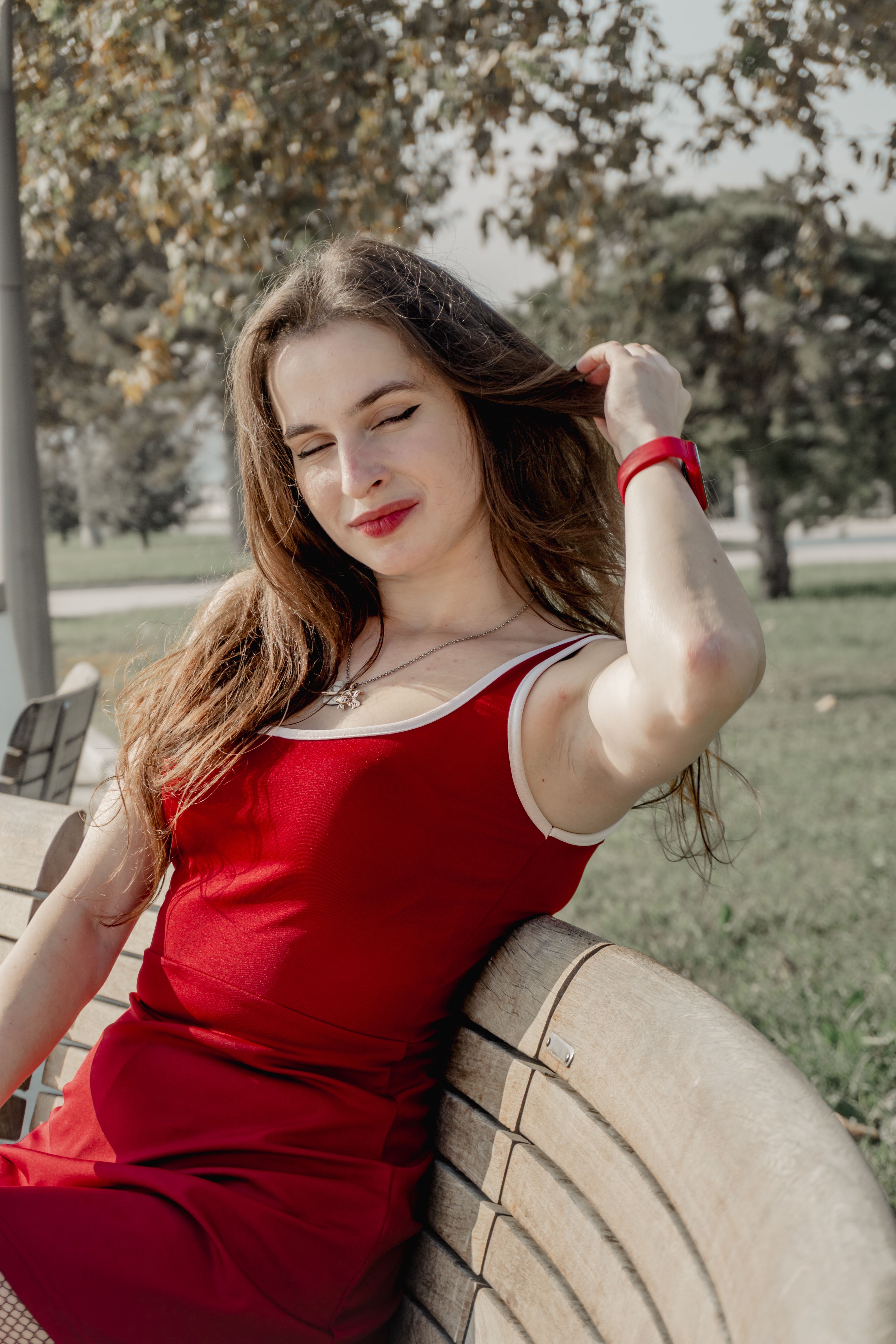Woman in Red Dress Relaxing on Park Bench · Free Stock Photo