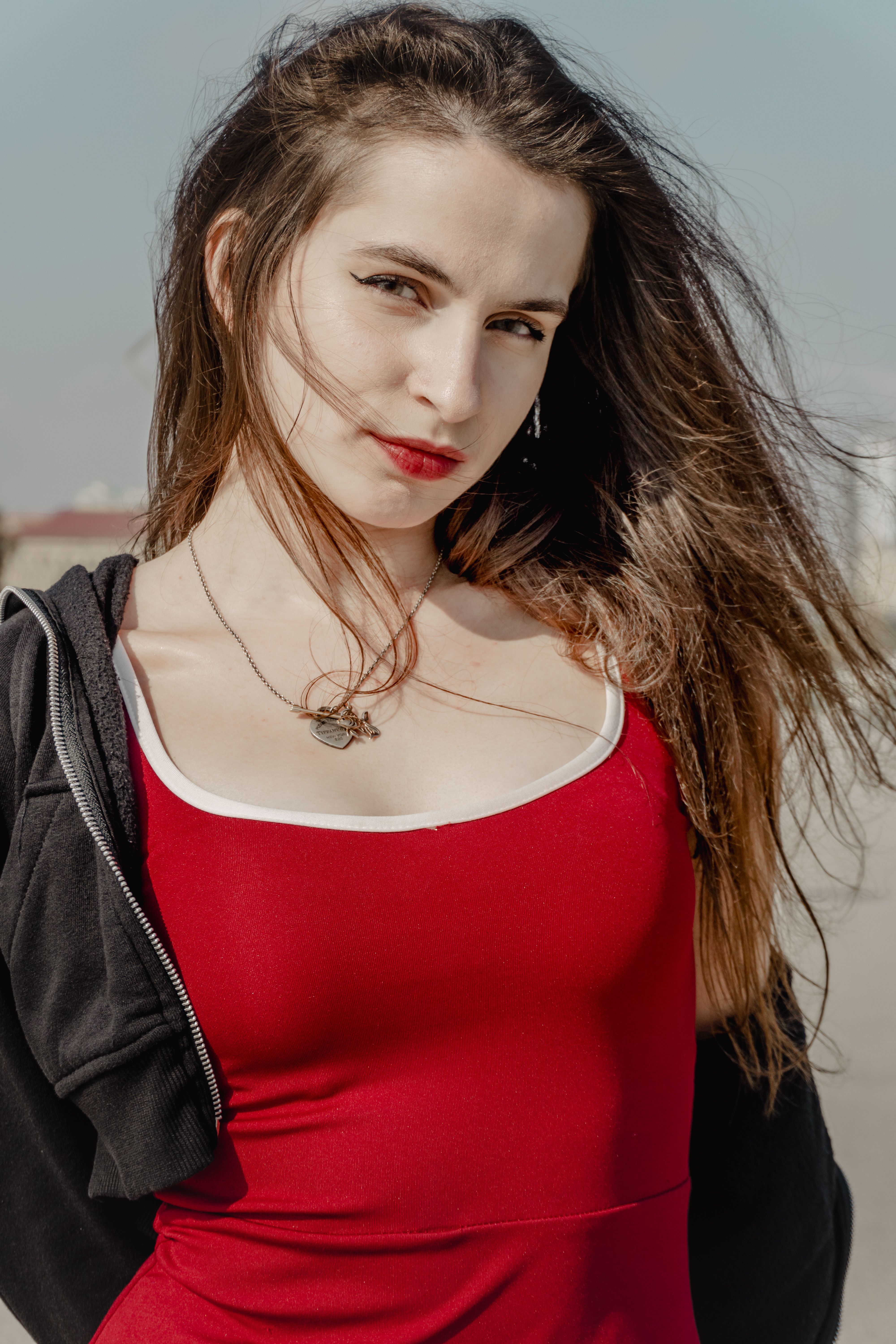 Confident Woman Posing in Red Dress Outdoors · Free Stock Photo