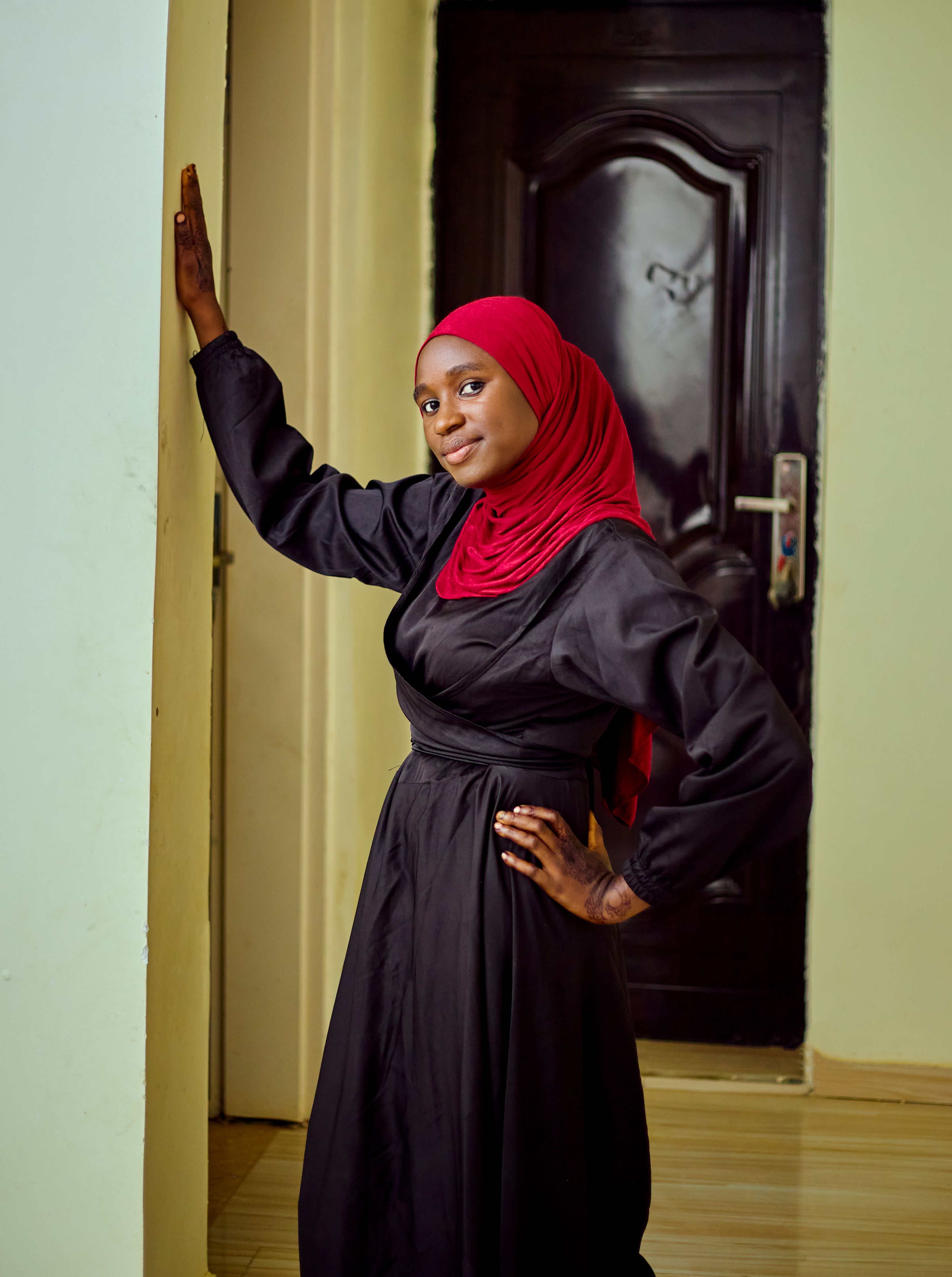 Confident Woman in Red Hijab Standing Indoors · Free Stock Photo