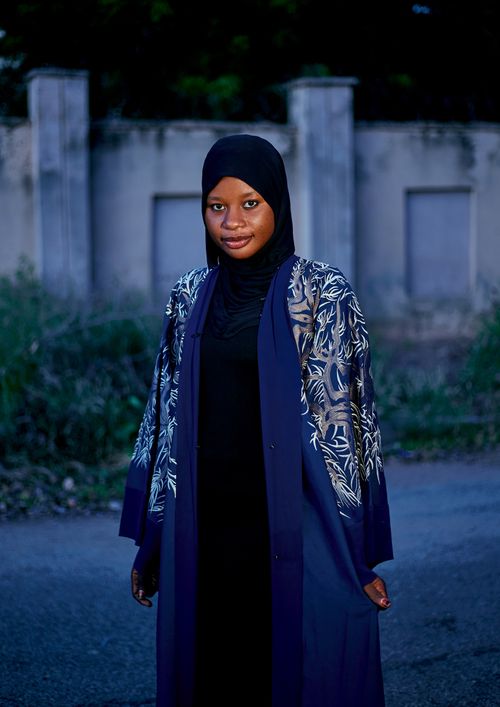 Free Elegant portrait of a woman in a floral patterned hijab outdoors at dusk. Stock Photo