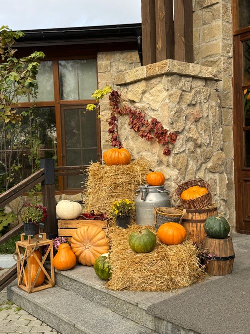 Free Autumn harvest scene featuring pumpkins, hay bales, and dried leaves by a stone building. Stock Photo