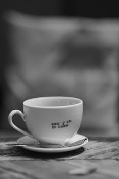 Black and white photo of a teacup on a saucer, perfect for modern decor.