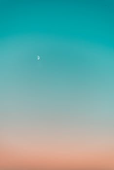 宁静的天空中，碧绿与桃色渐变的背景里悬着一弯半月