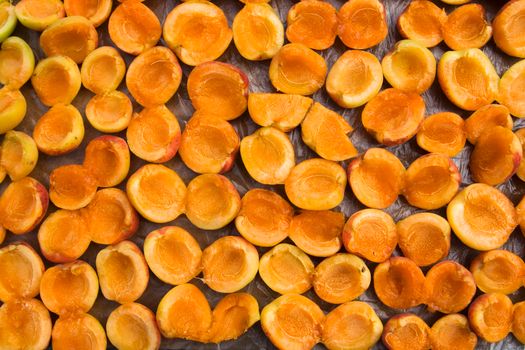 Vibrant and fresh apricots halved and laid out for drying, showcasing their rich orange hues.
