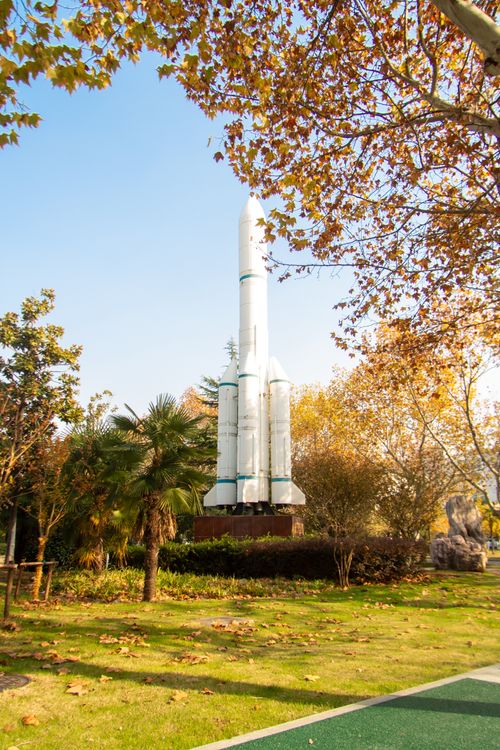 Free Model of a rocket surrounded by autumn trees in a scenic park setting. Stock Photo