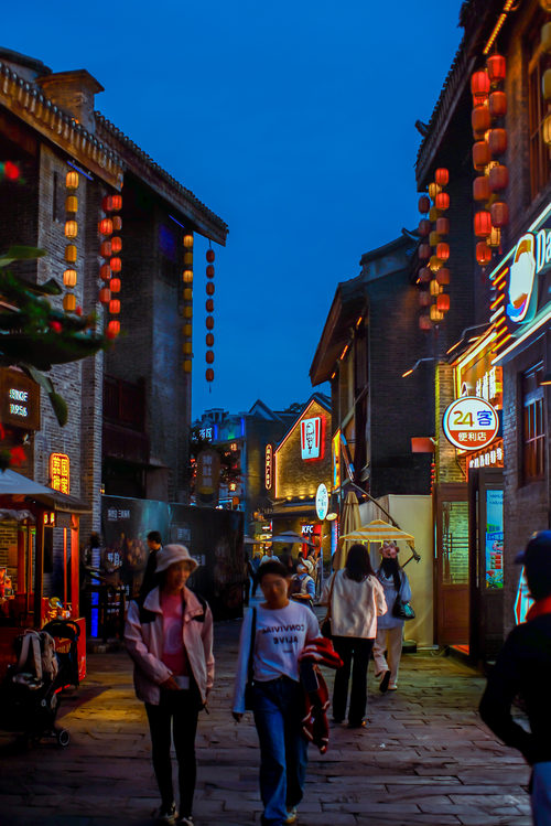 Free Nighttime scene in a vibrant Chinese market street with lanterns and shops. Stock Photo