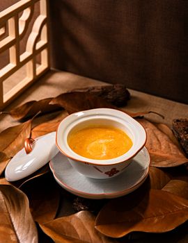 Aesthetic presentation of soup in a ceramic bowl surrounded by autumn leaves, evoking warm and cozy feelings.