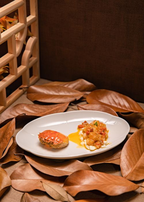 Free A gourmet crab dish beautifully presented on a bed of autumn leaves, perfect for fine dining themes. Stock Photo