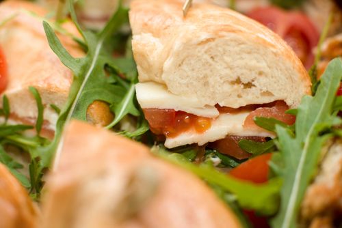 Free Delicious sandwich with cheese, tomato, and arugula on ciabatta bread. Stock Photo