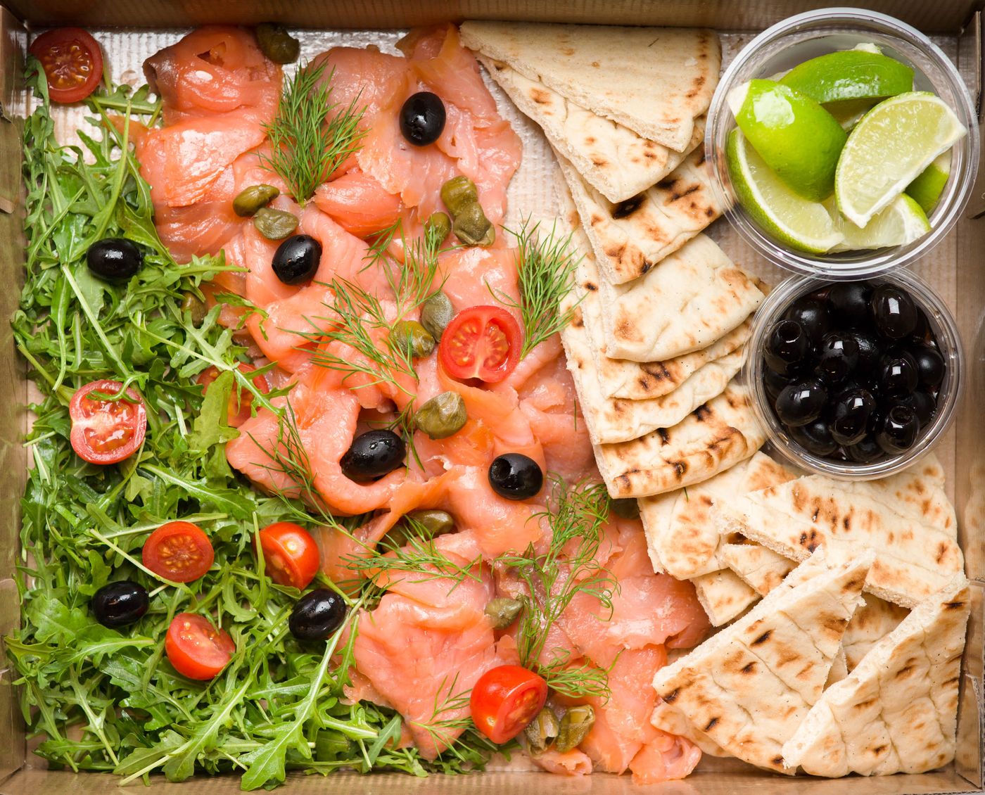 Deli platter of cured fish, capers, olives and flatbread. Photo by Novkov Visuals on Pexels.