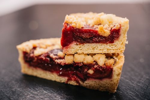 Free Mouth-watering cherry crumble bars with a golden crust, perfect for dessert. Stock Photo