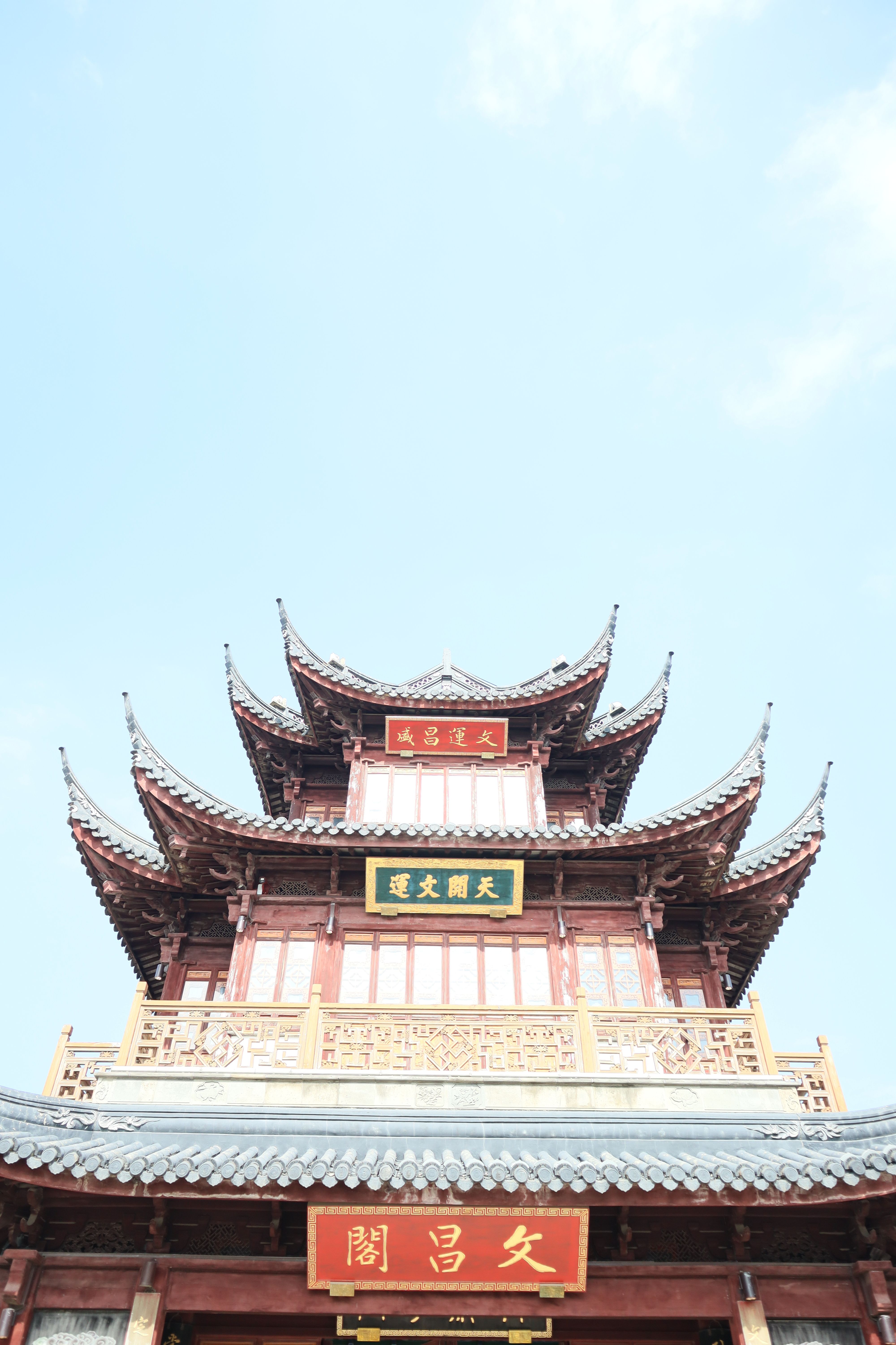A beautifully crafted traditional Chinese pagoda set against a vibrant blue sky with intricate architectural details.