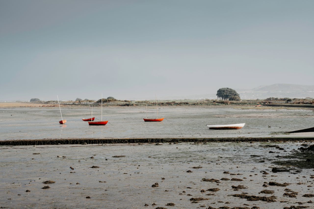 peaceful low tide landscape with moored boats in ireland showcasing se