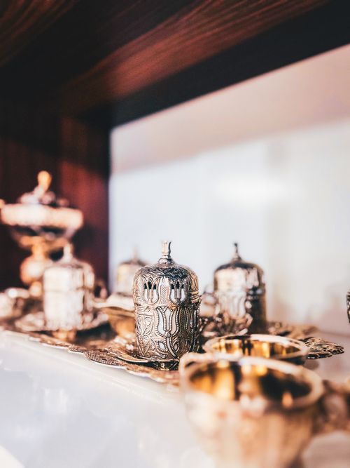 Free Intricate silver tea sets with ornate designs featured on a reflective surface. Stock Photo