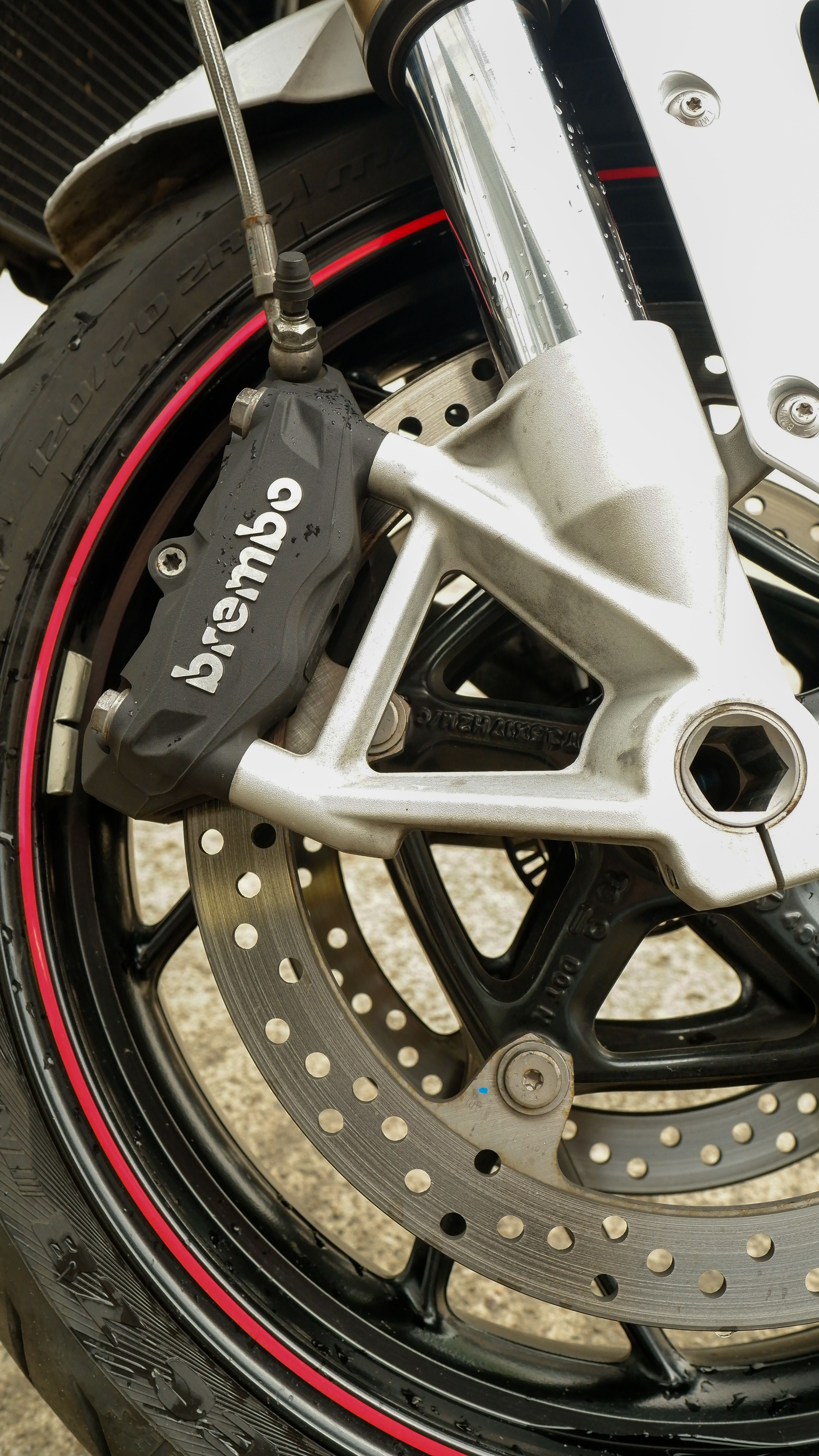 Detailed view of a motorcycle brake disc and caliper showcasing intricate mechanical design.