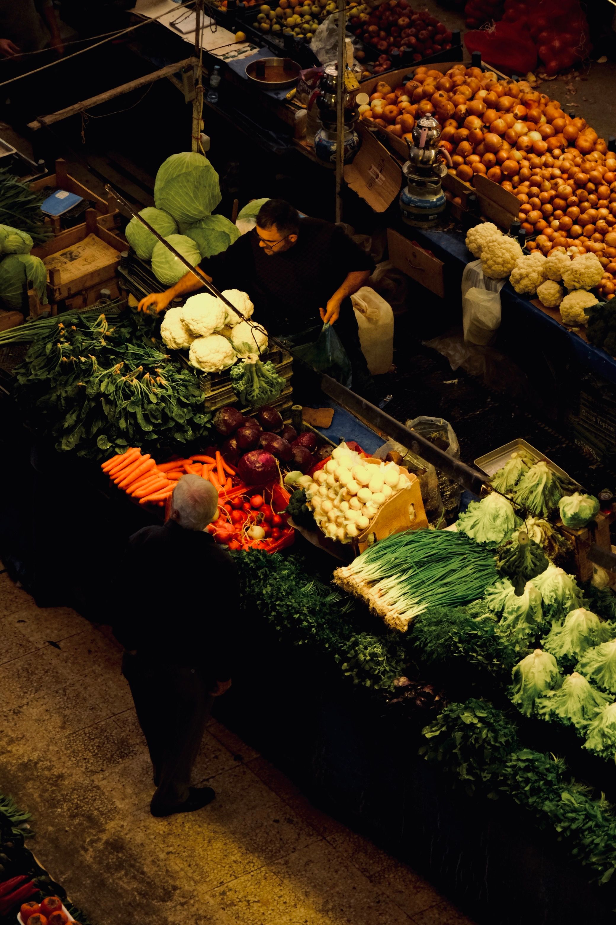 Top view of a bustling market stall selling fresh vegetables, creating a vibrant display.