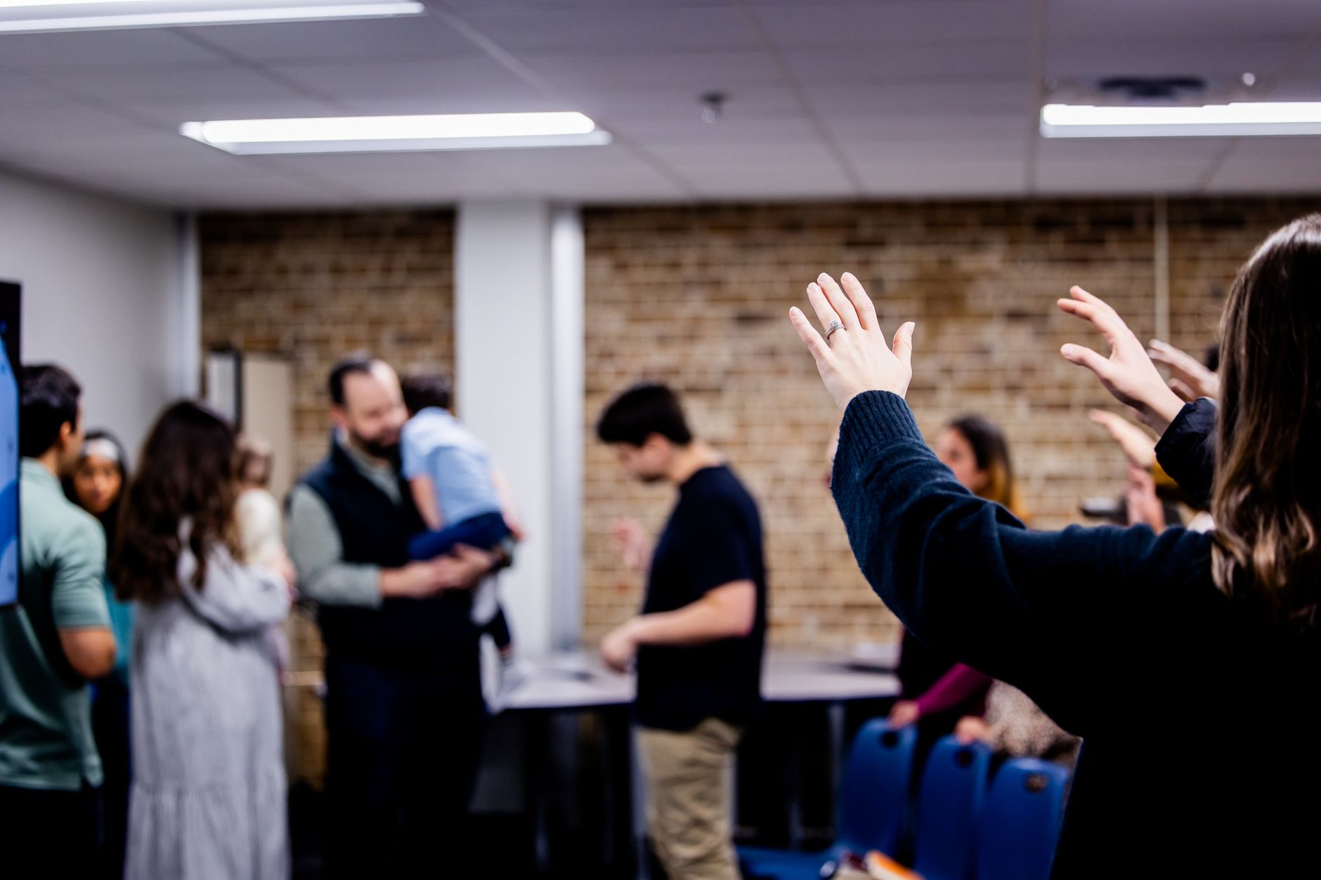People engaging in a casual group gathering indoors. Diverse adults mingling and interacting.