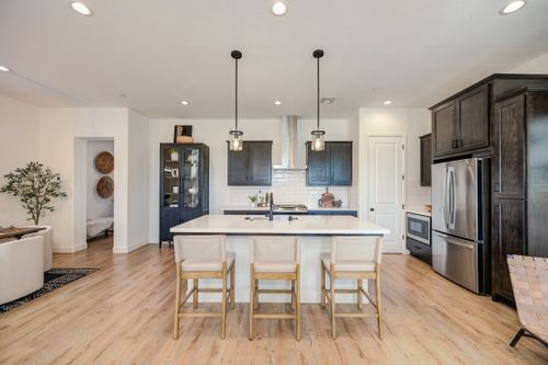 Free Sleek and stylish modern kitchen featuring a central island, pendant lights, and stainless steel appliances. Stock Photo