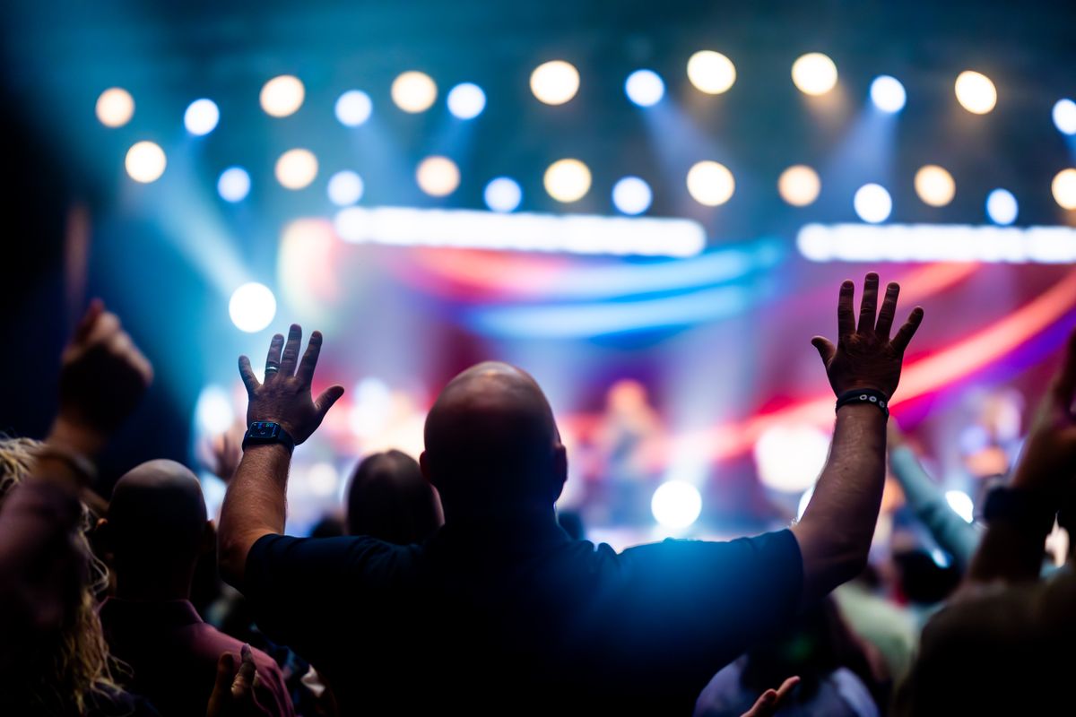Concert-goers enjoying a live performance with colorful stage lights
