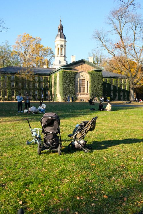 Free Ivy-covered Nassau Hall at Princeton University in autumn, with strollers on the lawn. Stock Photo