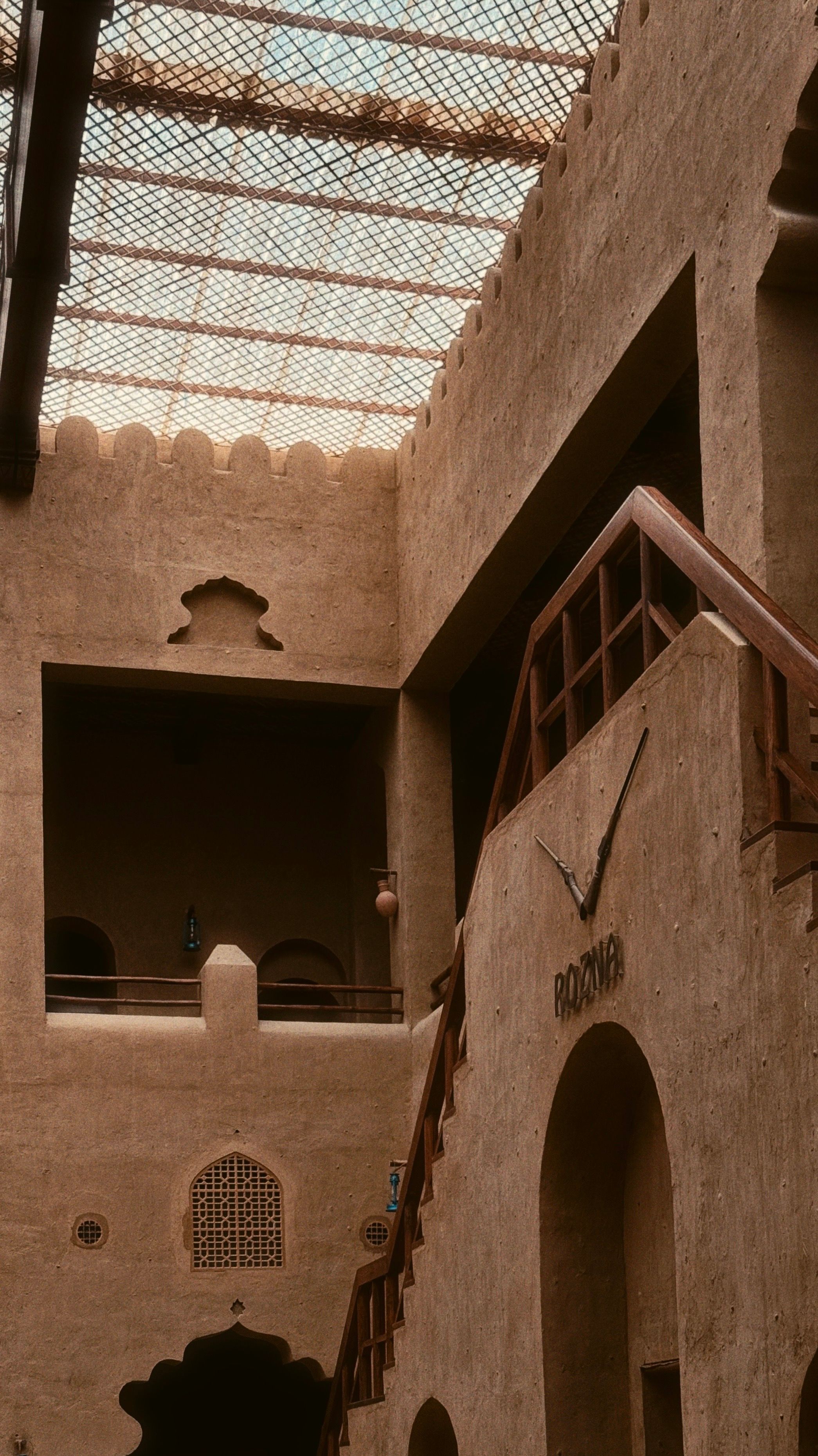 Explore the rustic charm of traditional Omani architecture in a sunlit indoor courtyard.
