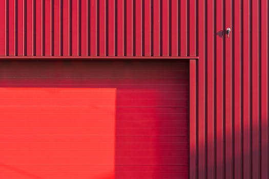 A sleek minimalist red facade with a large garage door, perfect for industrial themes.