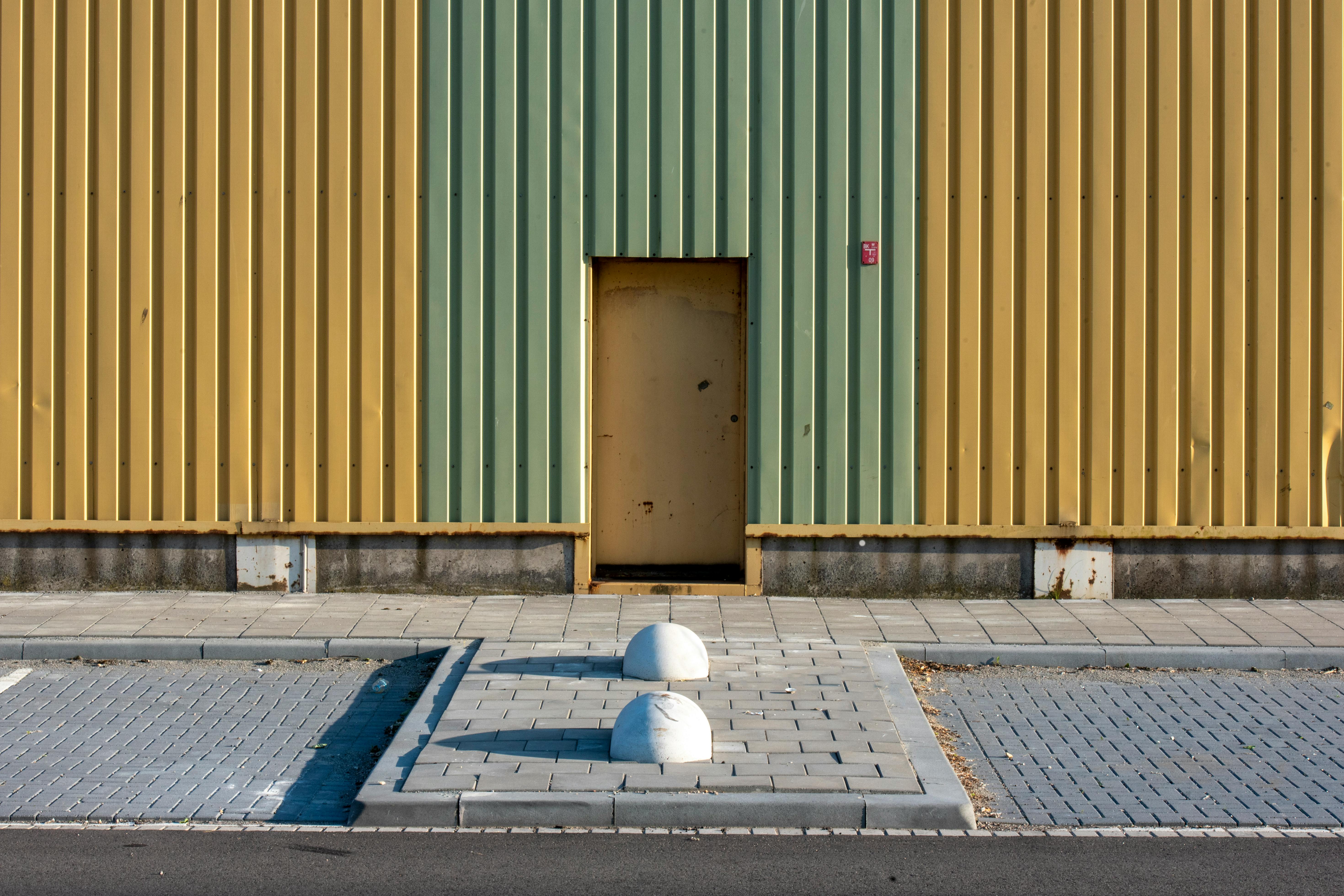 Gratis Fachada simétrica de edificio industrial con paneles verdes y amarillos y motivos geométricos. Vibrante y minimalista. Foto de stock