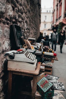 在繁忙的城市街道上，一台复古打字机陈列在户外的木桌上