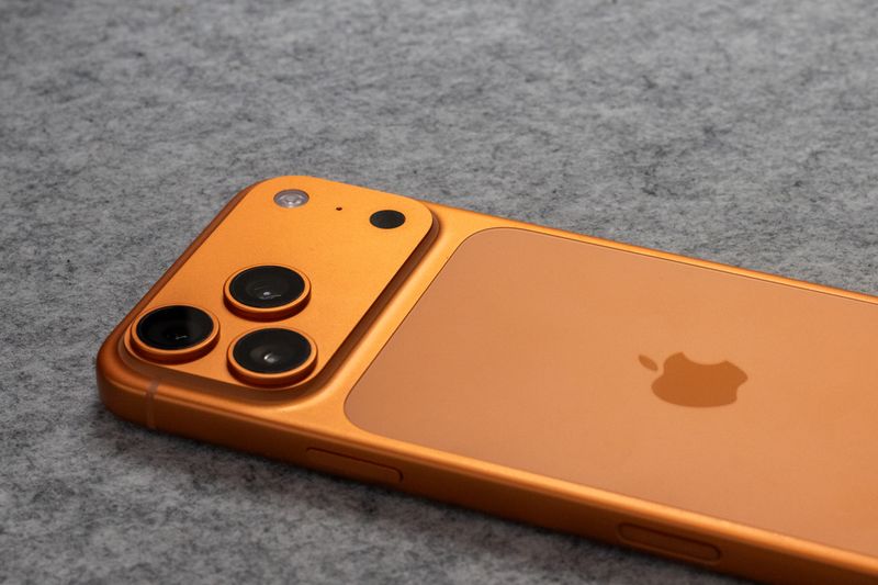 iPhone 17 series smartphone with dual camera on a gray surface