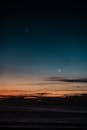 日落时分，充满活力的海平线上，新月与星星宁静地悬挂着