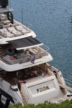Top view of a luxury yacht docked with lounging areas on a sunny day.